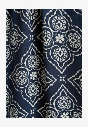 Marineblåt stof med hvide symmetriske blomster- og geometriske motiver, der danner et gentaget diamantmønster.