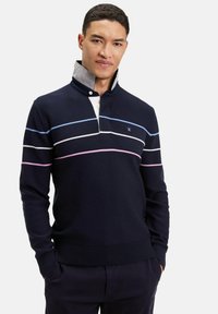 Pull marin avec un col et une patte de boutonnage à trois boutons. Présente des rayures horizontales en bleu clair, blanc et rose. Texture en maille.