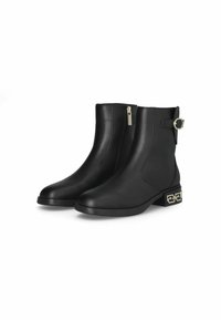 Stivali ankle in pelle nera con zip laterale, suola piatta e un accento metallico decorativo sul tallone. Presentano un dettaglio con cinturino e fibbia.