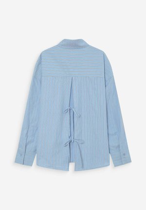 Camicia a maniche lunghe azzurro chiaro con righe bianche verticali e orizzontali, caratterizzata da una schiena aperta con due fiocchi annodati e polsini con bottoni.