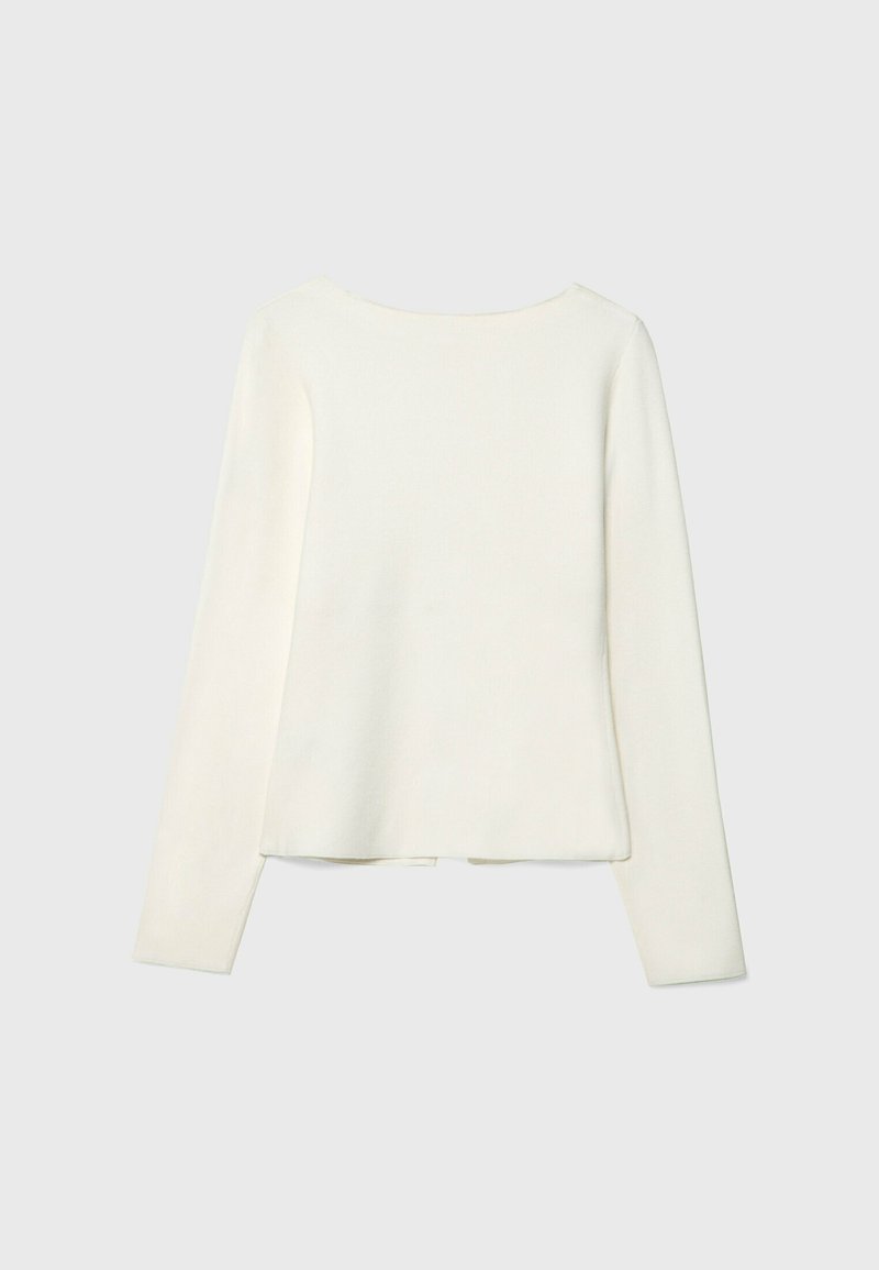 Maglietta a maniche lunghe in crema, realizzata in un morbido tessuto a maglia. Texture liscia, scollatura arrotondata e vestibilità comoda con orlo dritto.