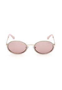 Lunettes de soleil ovales teintées de rose avec une monture en métal doré et des accents en strass le long des lunettes, avec des embouts de branches roses.