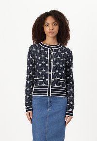 Navy cardigan with white floral pattern and details. Features a round collar, button closure, and two front pockets. Horizontal stripe accents.