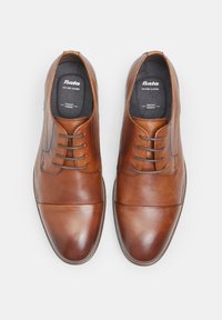Scarpe eleganti in pelle marrone con punta rotonda, design semplice, lacci frontali e una superficie liscia. Nome del brand stampato sulla soletta.