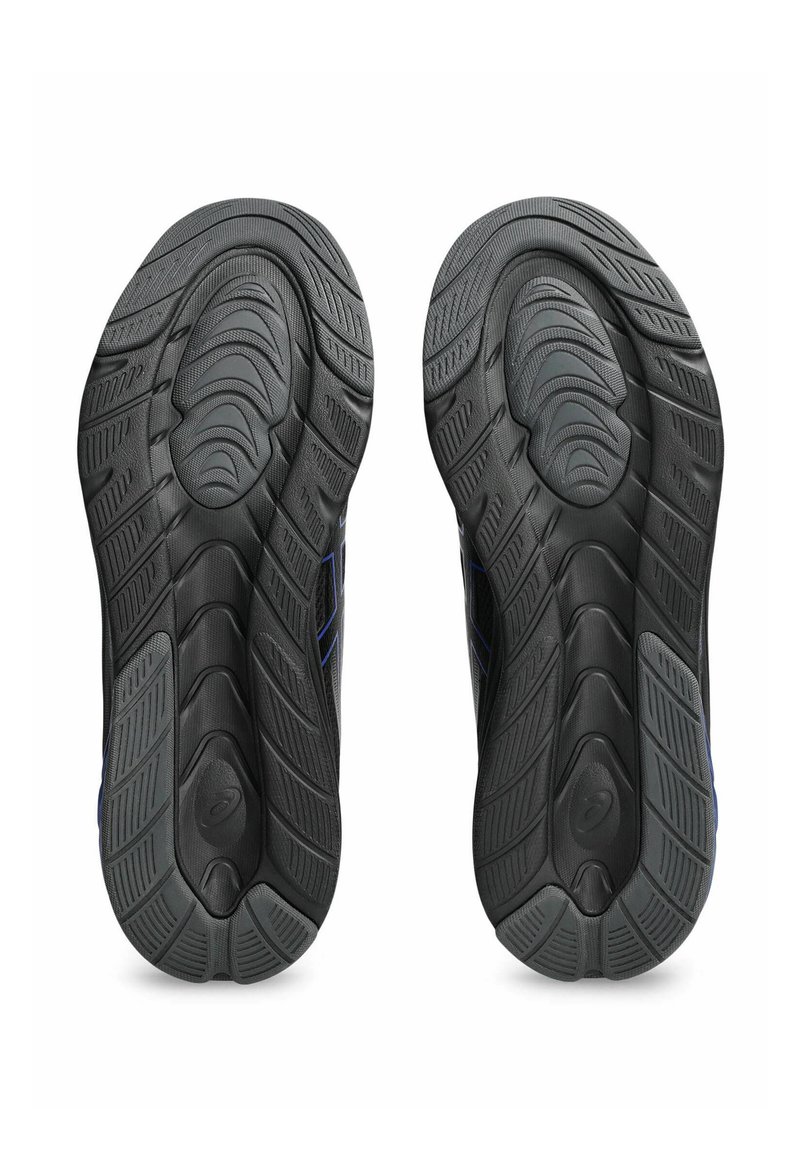 Schwarze Sport Schuhsohlen mit strukturierten Mustern und Rillen für besseren Halt. Mit einem blauen Akzent an der Seite jeder Sohle.