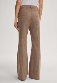 Bruin geruit broek met een wijde pijp ontwerp. Subtiele rode lijnen accentueren het patroon, met twee achterzakken en een getailleerde pasvorm.