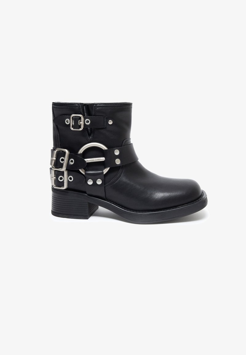 Melnas ādas potīšu zābaki ar noapaļotu purngali un zemu blokveida papēdi, ar vairākiem sudraba sprādzes un ovālu metāla akcenta siksnu.