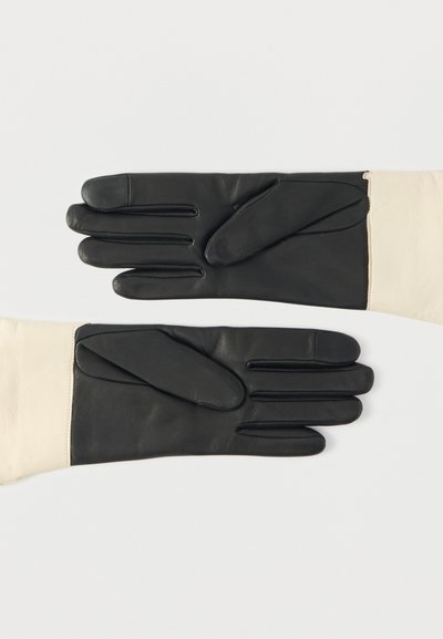 Mustad ja kreemjad nahkkindad, sileda tekstuuriga, pikliku kujuga ja peente õmblustega sõrmedel ning mansettidel.