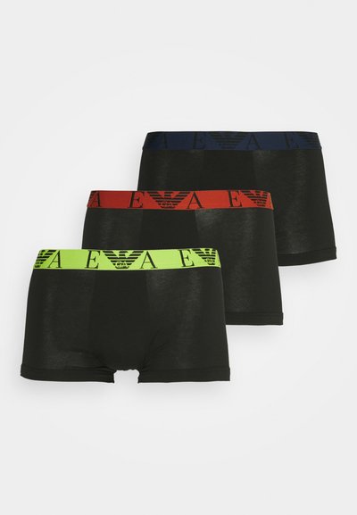 Tres pares de calzoncillos boxer negros con cinturillas elásticas contrastantes en verde, rojo y azul, presentando un patrón de logotipos.