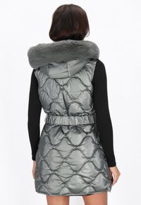 Vest gri cu umplutură, cu guler din blană sintetică, talie elastică și un model matlasat în formă de diamant, conceput pentru căldură și stil.