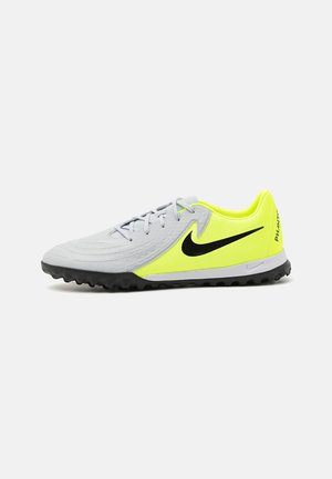 Grå fotbollsdojor med en texturerad ovandel, neongula detaljer, en svart Nike-swoosh och en gummiyttersula designad för grepp.