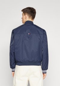 Tommy Hilfiger REVERSIBLE VARSITY JACKET - Bomberjacke - desert sky