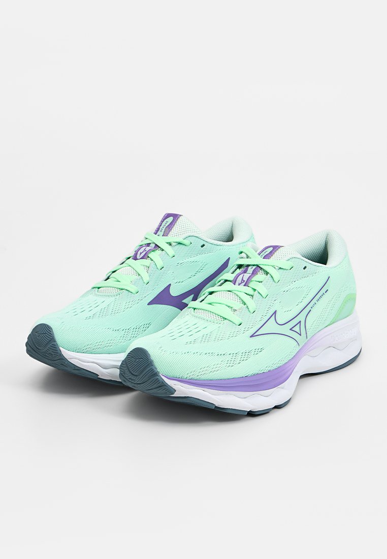 Zapatillas de running ligeras con una parte superior de malla verde menta, acentos morados y una suela blanca acolchada. Diseño de cordones con logotipos prominentes.