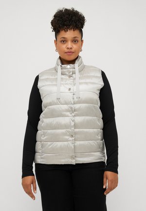 Silberne gepolsterte Weste mit hohem Kragen und vorderem Knopfverschluss, mit gestepptem Design und Kordelzug-Elementen, getragen über einem schwarzen Langarmshirt.