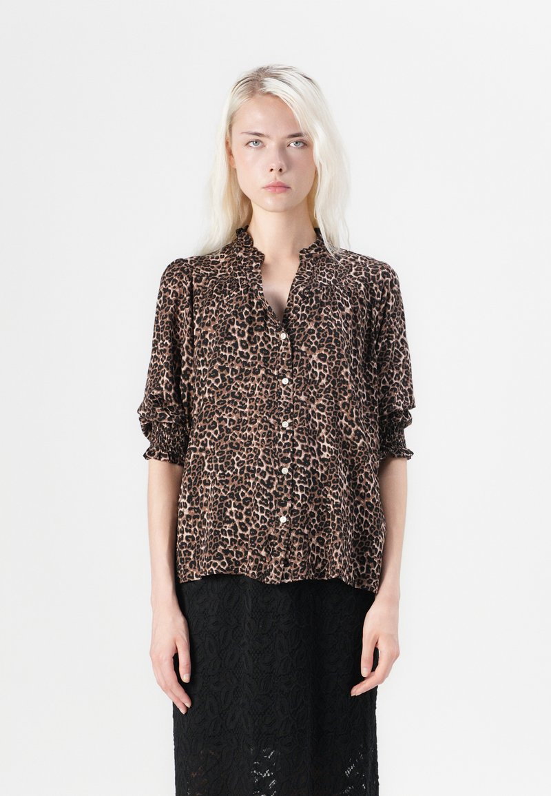 Bluza s leopard uzorkom u smešim i crnoj boji, s kragnom, dugmadi sprijeda i naboranim rukavima. Mekani, lagani materijal.