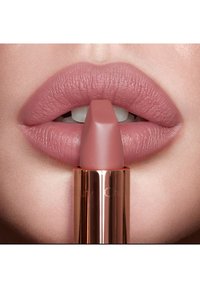 Volle Lippen mit aufgetragener matter Lila-Rosenholz-Lippenstift, nahe an einem passenden Lippenstift in Lila-Rosenholz, der aufrecht neben den Lippen gehalten wird.