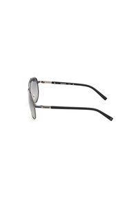 Gafas de sol con tintado gris, lentes ovalados y un marco ligero de acero inoxidable. Las patillas de goma negras presentan un detalle de logotipo.