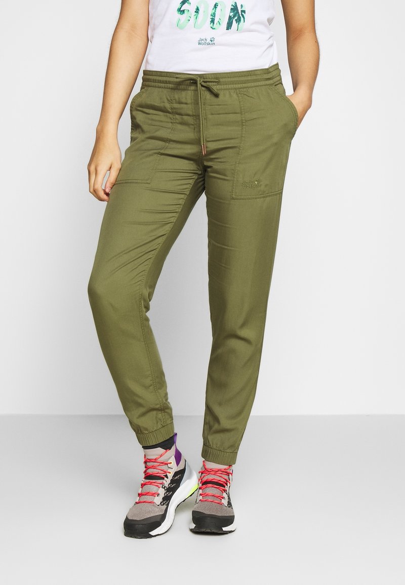 Olivgröna cargobyxor med dragsko i midjan, avsmalnande anklar och dragkedjefickor. Tillverkade av lätt, texturerad tyg.