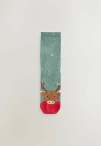 Groene sok met een bruine rendier met hoeven, die een rode sjaal draagt, en witte sneeuwvlokken verspreid over de stof.