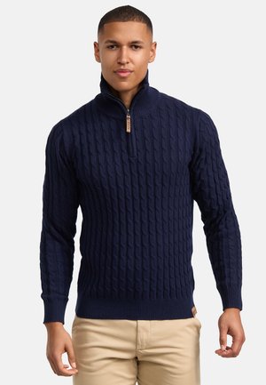 Navy blue knitted sweater with a high collar, featuring a textured cable pattern and zipper closure at the neck. Flat hem and ribbed cuffs.