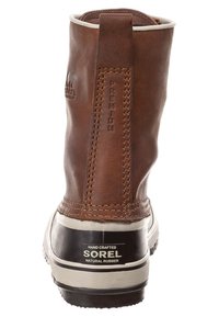 Hnědá kožená kotníková bota s texturovaným povrchem, poutkem a černou gumovou podrážkou. Obsahuje logo Sorel a detail "HAND CRAFTED".