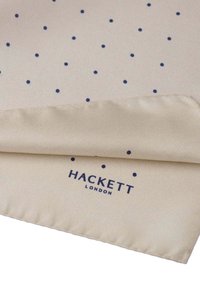 Bež svilen džepni rupčić s tamnoplavim točkicama i satenskim završetkom, s logotipom "HACKETT LONDON" blizu ruba.