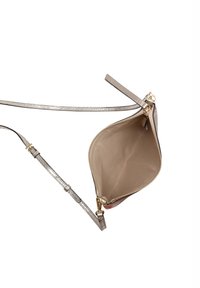 Bolso bandolera en cuero sintético beige, con cierre de cremallera, acentos metálicos y un forro interior suave. Correa adjunta para llevar.