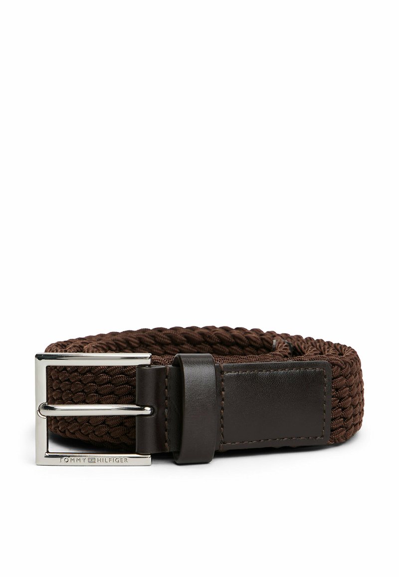 Ceinture en tissu brun tissé avec une boucle rectangulaire en métal argenté, présentant un accent en cuir foncé près de la boucle. La texture est tressée.