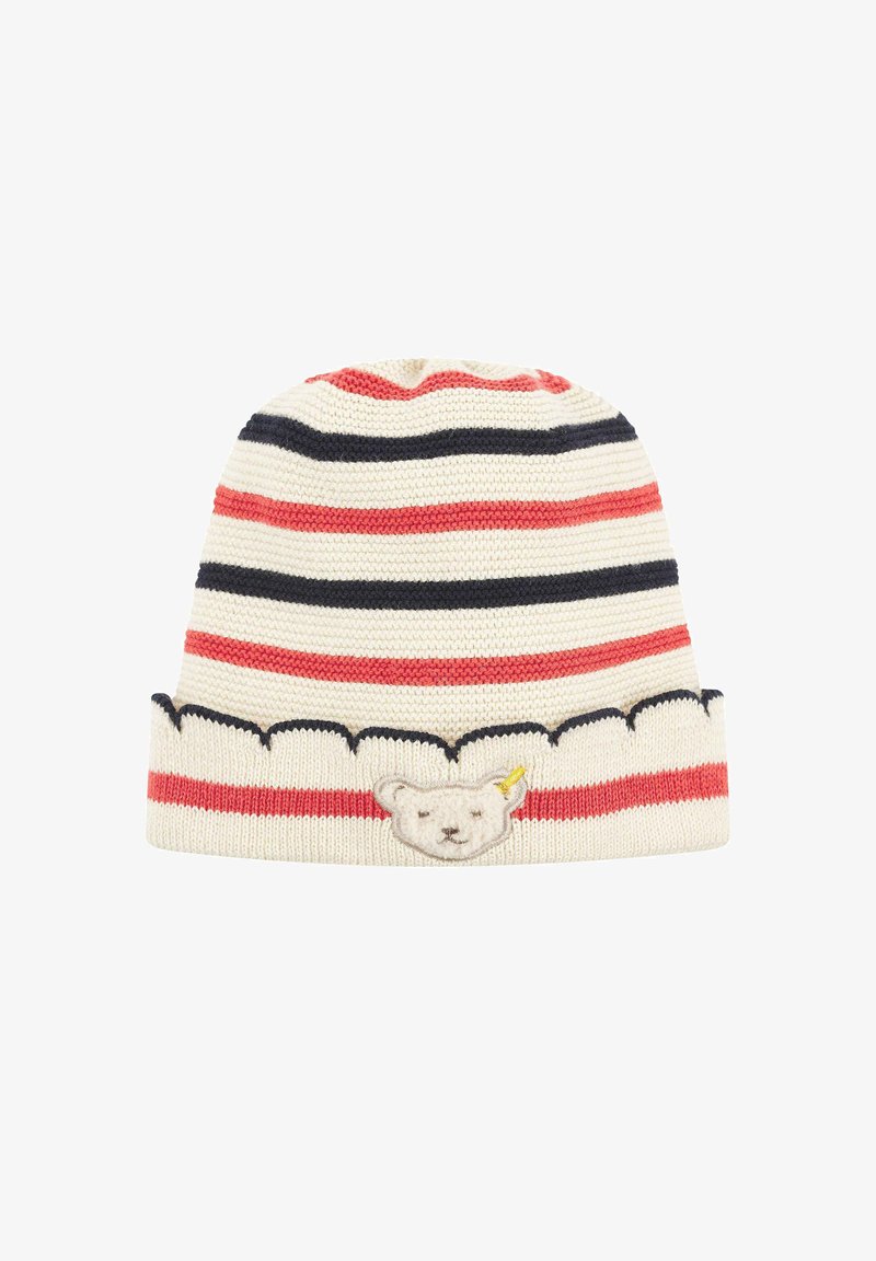 Striped knit beanie in cream, red, and navy. Features a bear face patch and scalloped edge at the bottom. Soft texture.