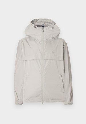 Lichtgrijze jas met ritssluiting en capuchon, elastische manchetten en een voorzak. Gemaakt van glad, licht materiaal met een subtiel logodetail.