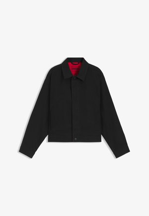 Zwarte cropped jas van gladde stof, met een knoopsluiting, een kraag en een contrasterende rode voering aan de binnenkant.