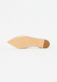 Semelle de chaussure à bout pointu en tan avec une finition lisse. Présente une section supérieure transparente et un talon discret pour un peu de hauteur. Design minimaliste.