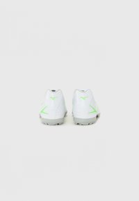 Zapatillas deportivas blancas con acentos en verde neón, parte superior sintética suave, diseño de corte bajo y suela de goma texturizada con clavos antideslizantes.