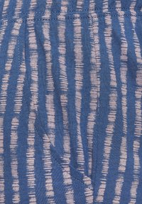 Blue fabric with pink vertical stripes. Features an elastic waistband and side pockets. Texture appears soft and slightly brushed.