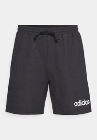 Black cotton shorts with an elastic waistband, drawstring, and white adidas logo on the lower left side. Smooth texture, knee-length design.