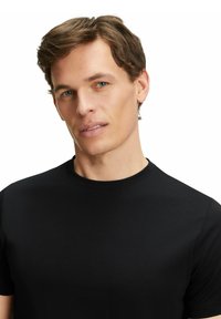 Black cotton t-shirt with a crew neck, short sleeves, and a smooth texture, featuring a fitted silhouette and minimal design details.