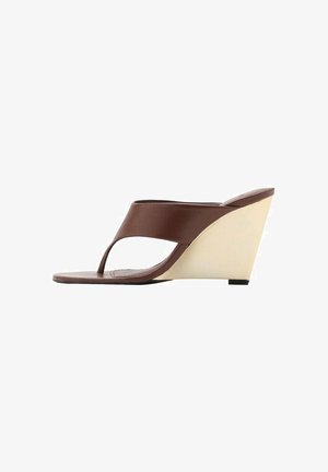 Sandales compensées marron avec une large bride lisse sur le devant, design ouvert à l'avant, et un talon compensé de couleur crème contrastante.