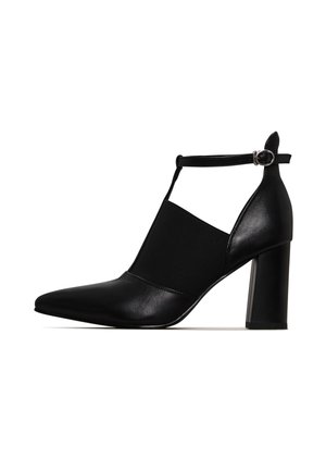 Schwarzer High-Heel-Schuh mit spitzer Zehenpartie, Lederoberteil, elastischem Seitenpanel und Knöchelriemen mit Schnalle. Glatte Textur und Blockabsatz.