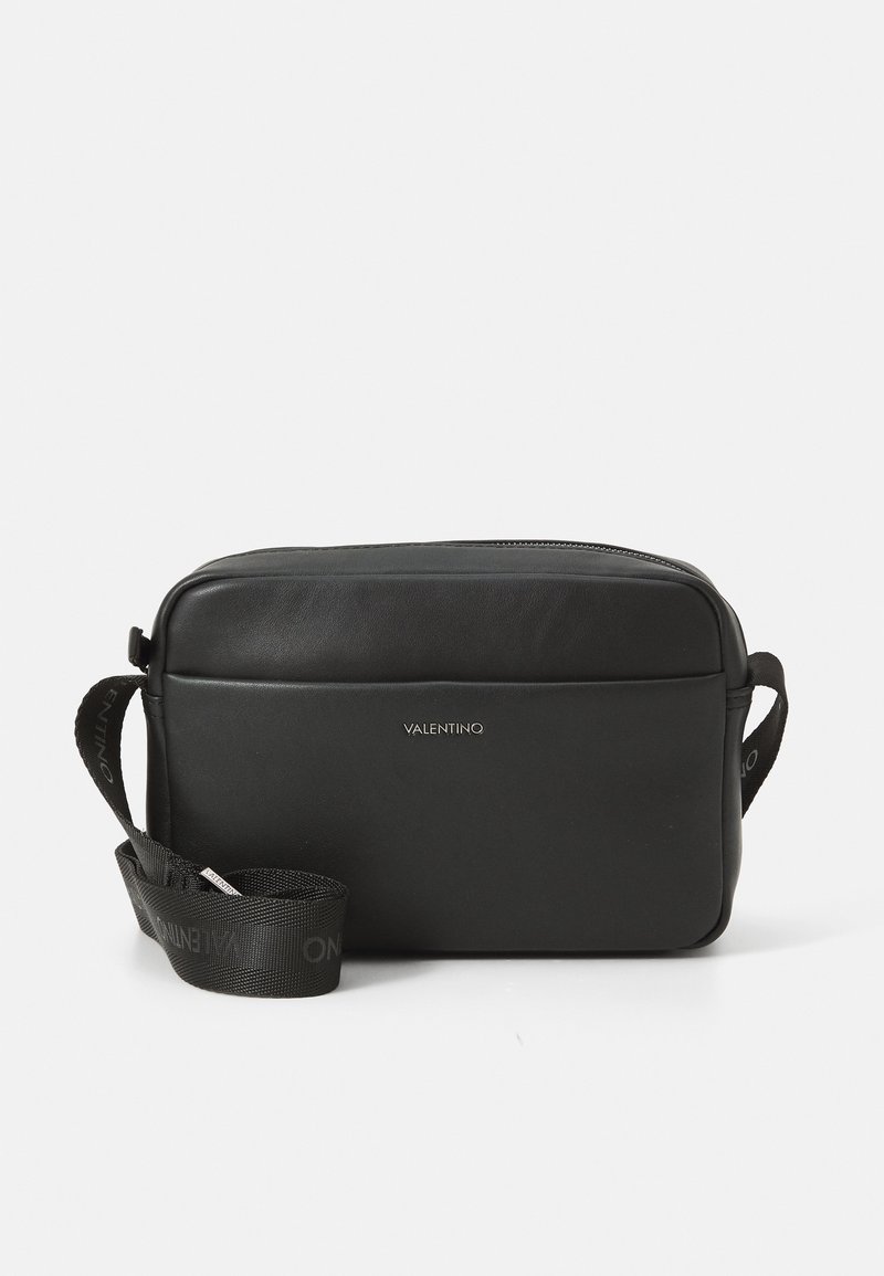Melnas ādas crossbody soma ar rāvējslēdzēju, plakanu taisnstūrveida formu un logotipa detaļu. Aprīkota ar strukturētu siksnu ar zīmola apzīmējumu.