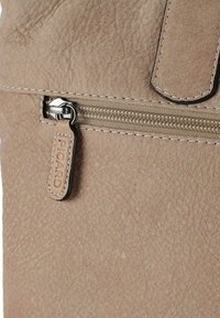 Beige Leder-Zipper-Pouch mit strukturierten Oberfläche, cremefarbenen Nähten und einem kleinen Lederetikett, das mit "PICARD" geprägt ist. Der Reißverschluss zieht ist metallisch.