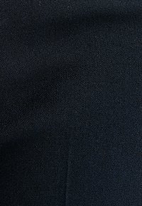 Gestructureerde zwarte stof met een geweven patroon, met een matte afwerking en een uniforme oppervlak met minimale schaduwvariaties.