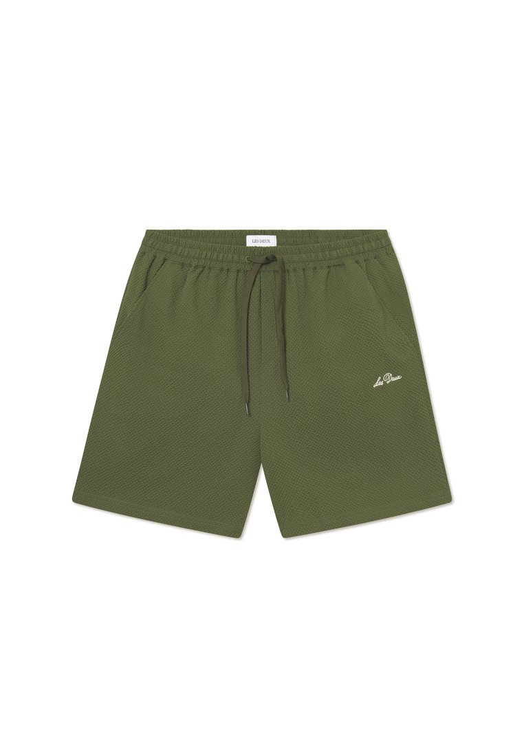 Shorts de sport verts en tissu texturé, dotés d'une taille élastique, d'un cordon de serrage et d'un petit logo blanc sur l'avant.