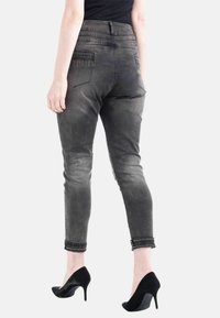 Grå denim skinny jeans med en texturerad midja och dekorativa nitar på bakfickorna, som har en smal passform och ankellängd.