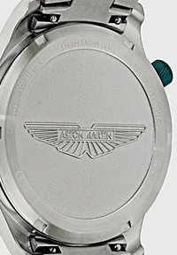 Retro in acciaio inossidabile del orologio Aston Martin, con logo incastonato, viti visibili e una corona blu sul lato.