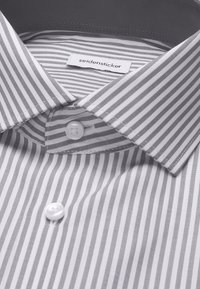 Wit overhemd met dunne grijze verticale strepen, een knoopsluiting bij de kraag en het merklabel "seidensticker" aan de binnenkant van de hals.