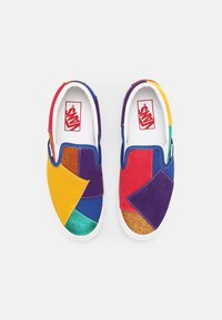 Tenisky Vans slip-on s designem patchwork v modré, zelené, červené, žluté, fialové a třpytivé zlaté barvě, s bílou gumovou podrážkou.