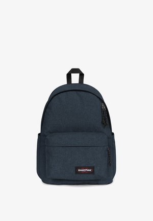 Zaino in tessuto blu con parte superiore arrotondata, tasca frontale e patch con logo. Presenta cerniere nere e materiale texturizzato. Spallacci regolabili.