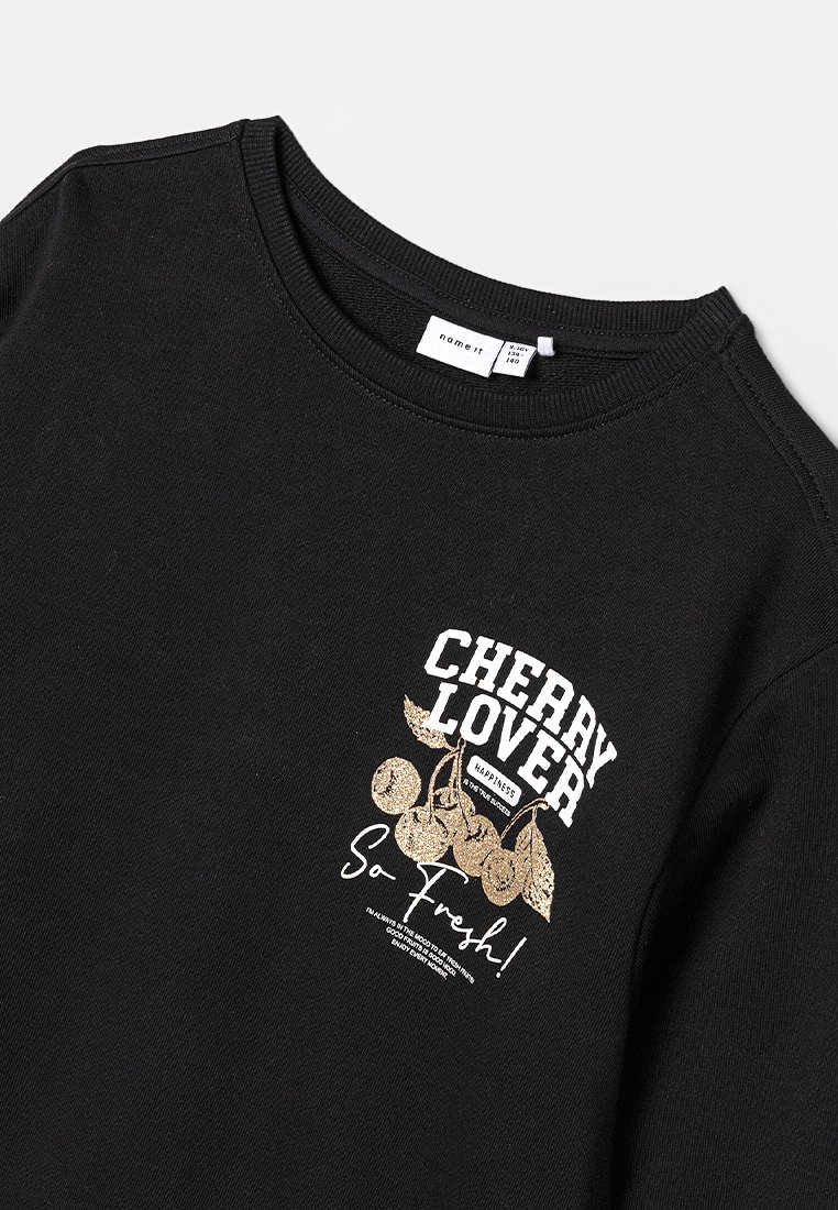 Schwarzer Pullover mit einem weißen und goldenen "Cherry Lover"-Grafik, die Kirsch-Illustrationen und den Spruch "So Fresh!" in stilisierter Schrift zeigt.