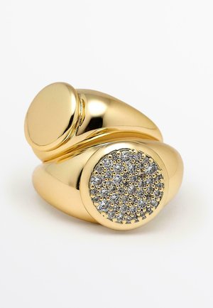 Gold-colored ring with a smooth, rounded band. Features a round, textured setting with multiple small, sparkling stones.
