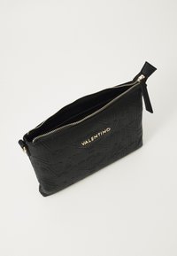 Bolsa de mão preta em couro com padrão de logotipo em relevo, fecho dourado e pormenores texturizados. Apresenta uma forma retangular elegante.